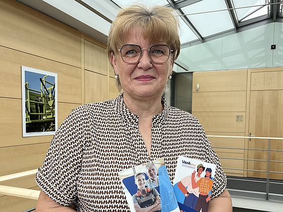 Birgit Augustin hält zwei Flyer zu VerAplus.