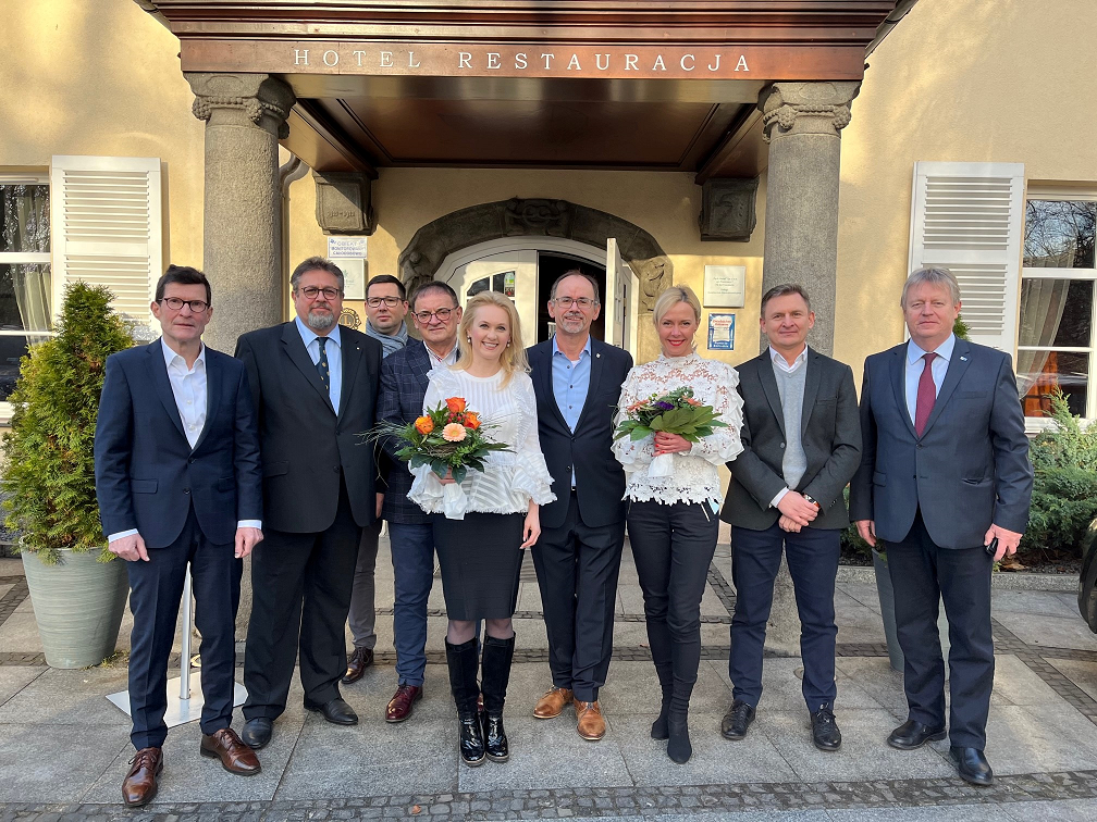 Auf dem Bild sind insgesamt neun Personen zu sehen, die vor einem Gebäude posieren. Es sind die Präsidien der IHK Neubrandenburg für das östliche Mecklenburg-Vorpommern und der Wirtschaftskammer Nord Stettin zu sehen. In der Mitte stehen die Präsidentin der Wirtschaftskammer Nord, Hanna Mojsiuk und der Präsident der IHK, Dr. Wolfgang Blank.