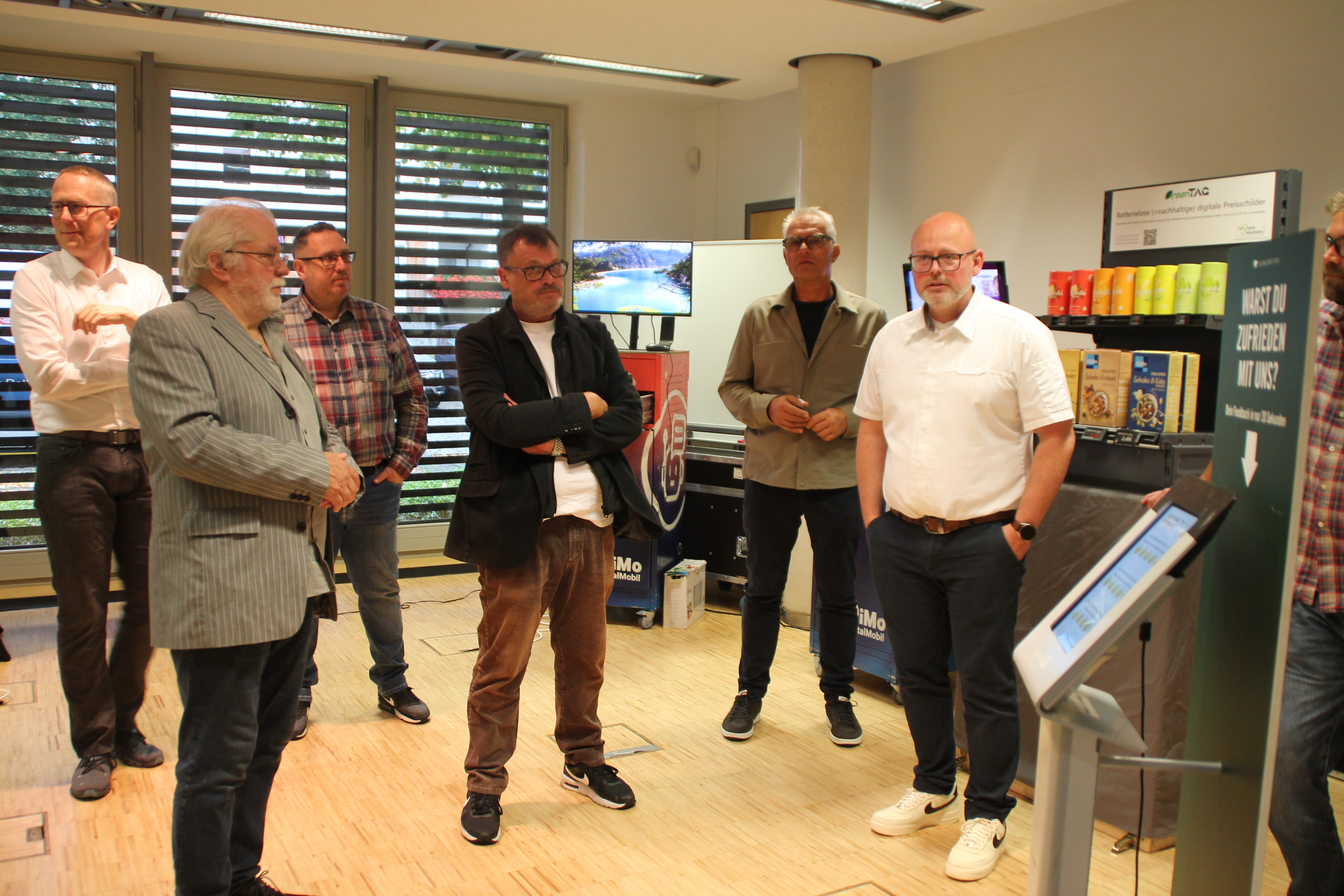 Menschen besprechen sich stehend im Kreis.